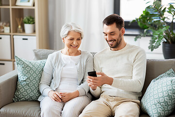 Image showing old mother and adult son with smartphone at home