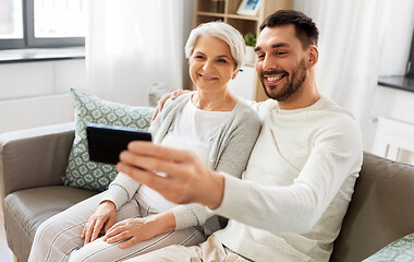 Image showing senior mother with adult son taking selfie at home