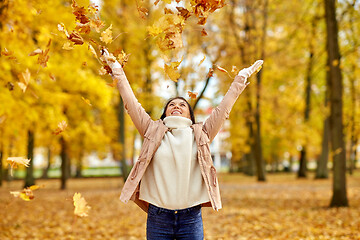 Image showing happy woman having fun with leaves in autumn park