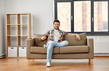 Image showing happy man sitting on sofa at new home