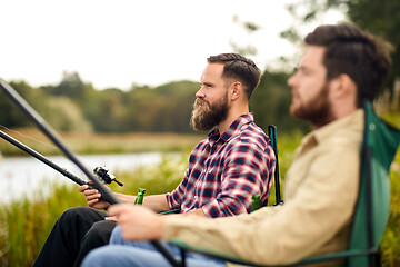 Image showing friends with fishing rods at lake or river