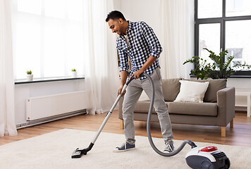 Image showing indian man with vacuum cleaner at home