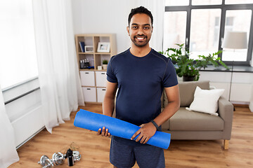 Image showing smiling indian man with exercise mat at home