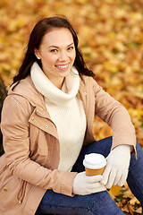 Image showing woman drinking takeaway coffee in autumn park