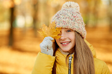 Image showing portrait of girl with maple leaf at autumn park