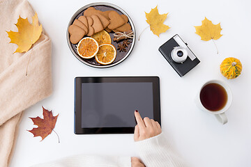 Image showing hands with tablet pc, tea and autumn leaves