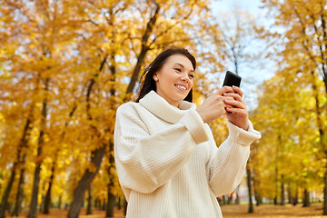 Image showing woman with smartphone in autumn park