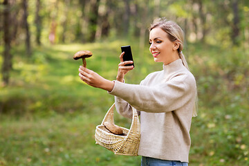 Image showing woman using smartphone to identify mushroom