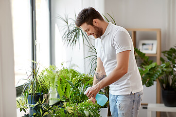 Image showing man spraying houseplants with water at home