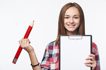 Image showing Girl holding big pencil and blank paper sheet on tablet