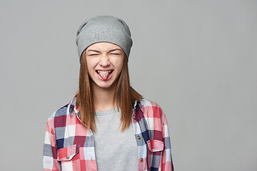 Image showing Teen girl screwing up her eyes and showing the tongue