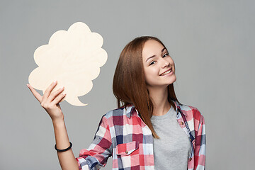 Image showing Smiling girl holding thinking bubble looking at camera