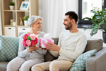 Image showing son giving present and flowers to senior mother