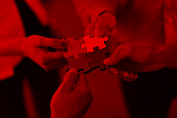 Image showing Group of business people assembling jigsaw puzzle