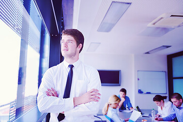 Image showing business man  on a meeting in offce with colleagues in backgroun