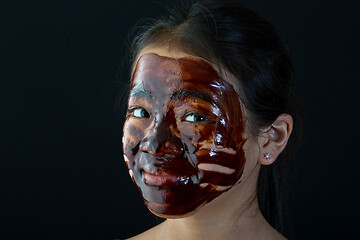 Image showing young asian girl having fun with a chocolate mask