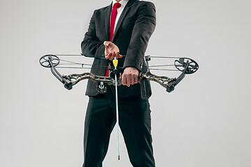 Image showing Businessman aiming at target with bow and arrow, isolated on white background