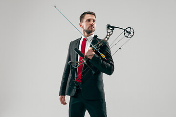 Image showing Businessman aiming at target with bow and arrow, isolated on white background