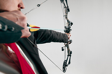 Image showing Businessman aiming at target with bow and arrow, isolated on white background