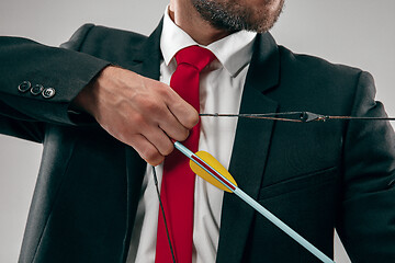 Image showing Businessman aiming at target with bow and arrow, isolated on white background