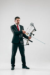 Image showing Businessman aiming at target with bow and arrow, isolated on white background