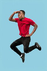 Image showing Freedom in moving and forward motion. The happy surprised young afro man jumping