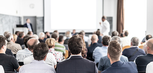 Image showing I have a question. Group of business people sitting in conference hall. Businessman raising his arm. Conference and Presentation. Business and Entrepreneurship