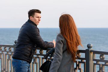 Image showing Two young people discuss the situation on the beach