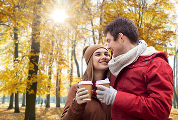 Image showing happy couple with coffee walking in autumn park