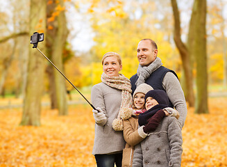 Image showing happy family with smartphone and monopod in park