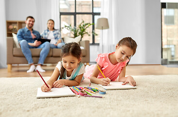 Image showing happy sisters drawing in sketchbooks at home