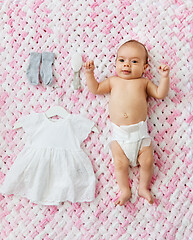 Image showing baby girl in diaper lying with dress on blanket