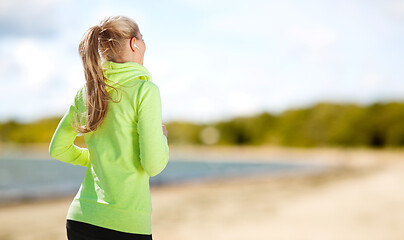 Image showing woman with earphones running at park