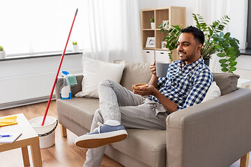 Image showing man drinking coffee, resting after home cleaning