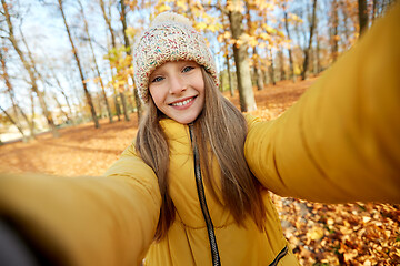Image showing happy girl taking selfie at autumn park