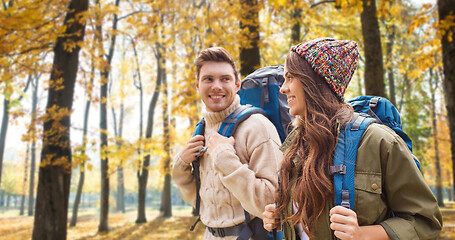 Image showing smiling couple with backpacks hiking in autumn