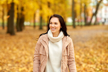 Image showing beautiful happy young woman smiling in autumn park