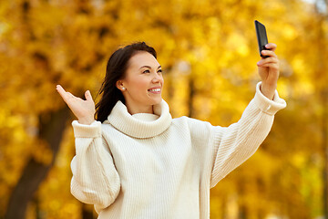 Image showing woman taking selfie by smartphone at autumn park