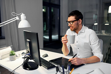 Image showing designer with pen tablet drinking coffee at office