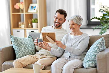 Image showing adult son and senior mother with photo at home