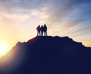 Image showing group of travelers with backpacks over sunrise