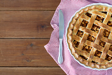 Image showing close up of apple pie in baking mold and knife