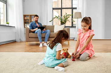 Image showing girls playing with toy crockery and teddy at home