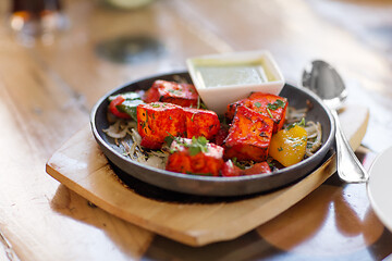 Image showing close up of paneer tikka dish with sauce on table