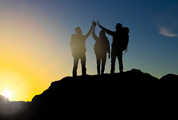 Image showing travelers making high five over sunrise