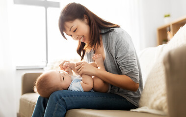 Image showing happy young mother with little baby son at home