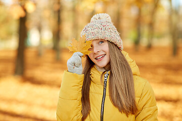 Image showing portrait of girl with maple leaf at autumn park