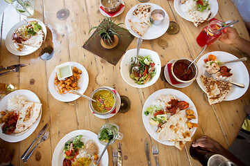 Image showing african american friends eating at restaurant