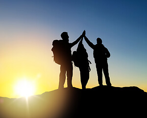 Image showing travelers making high five over sunrise