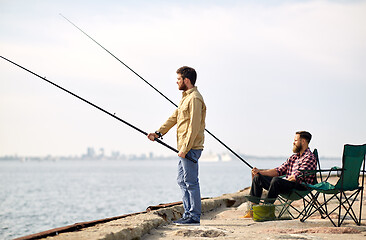 Image showing happy friends with fishing rods on pier